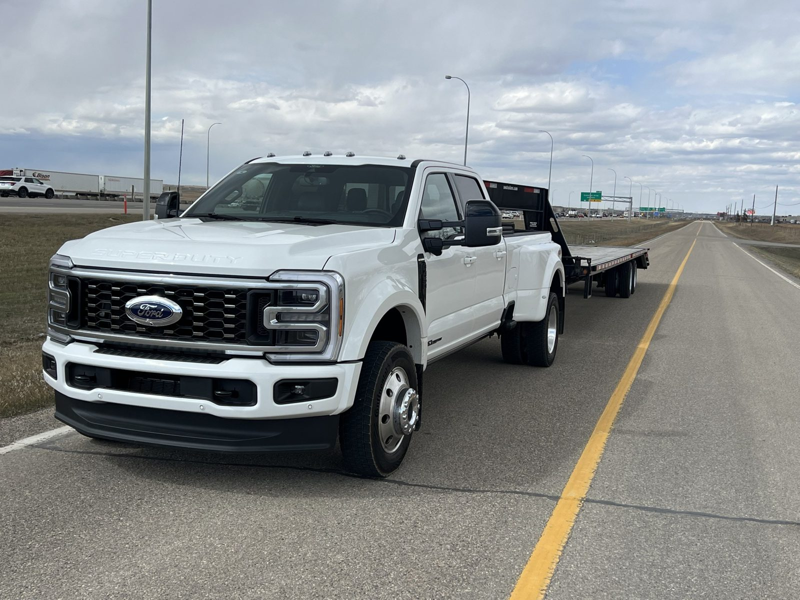 Logistics Service World Ford dually and gooseneck flatbed on an Alberta highway