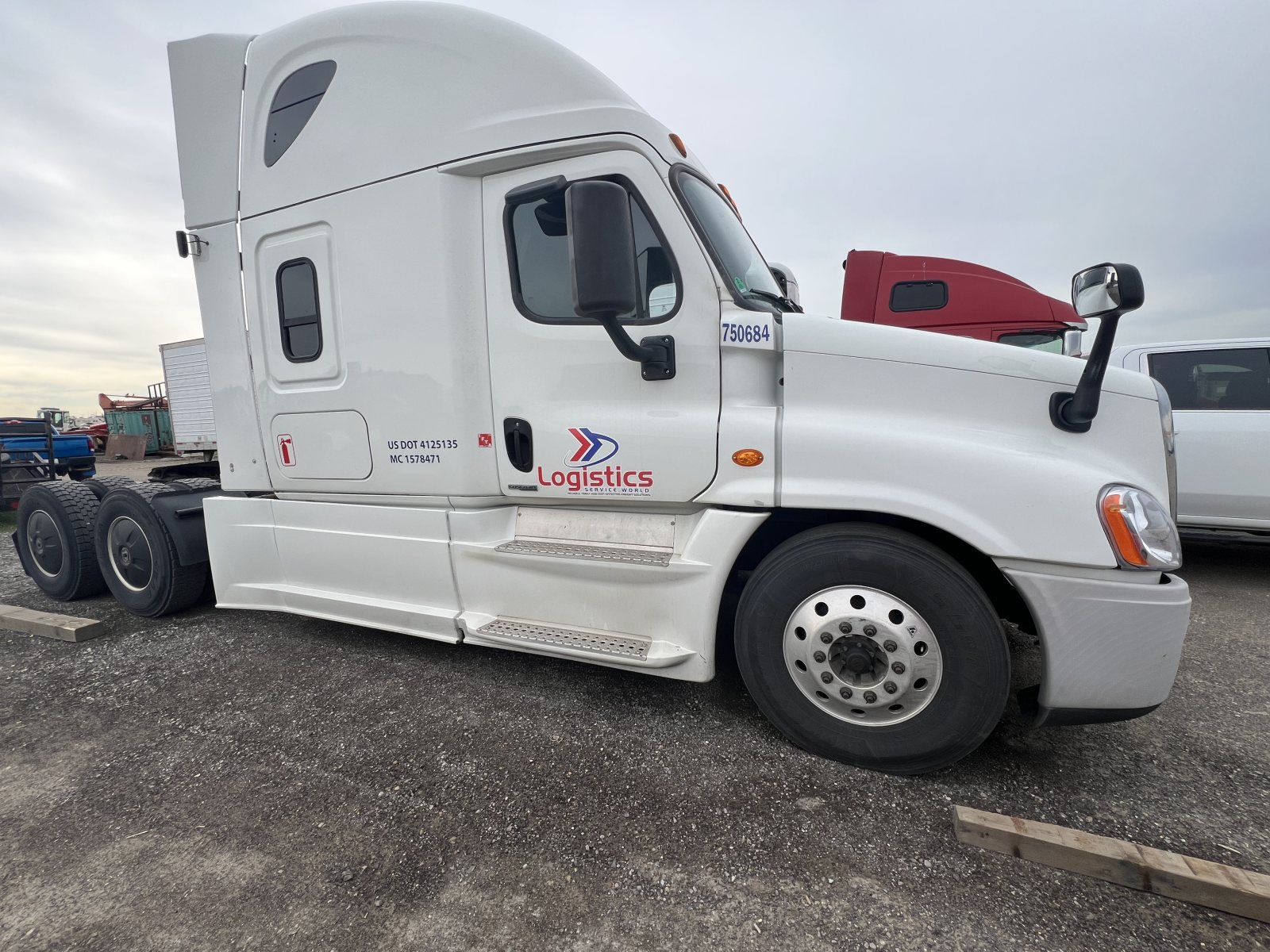 White Freightliner sleeper tractor with Logistics Service World decal